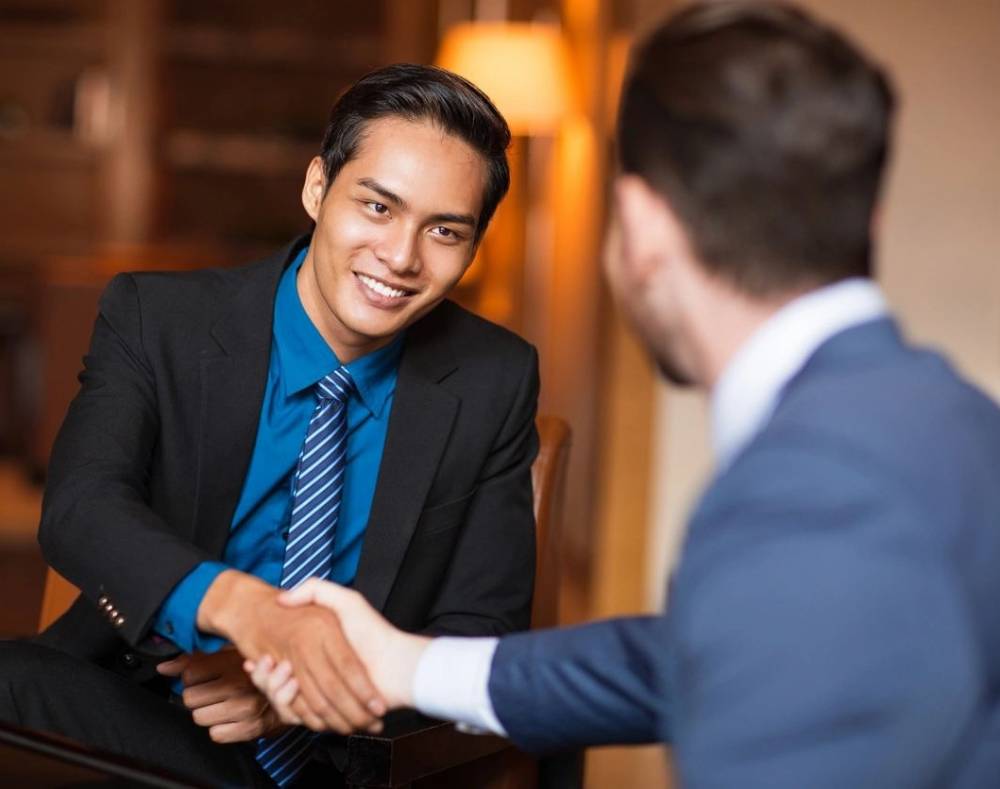 Closeup of two smiling business men shaking hands